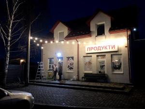a man standing outside of a shop at night at Motel M19 in Lipiny