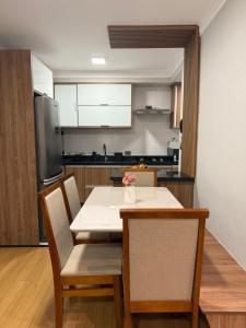 a kitchen and dining room with a table and chairs at Carvalho Home in Londrina