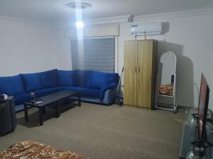 a living room with a blue couch and a table at Kamaliyeh studio in Amman +2 photos