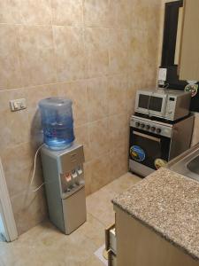 a kitchen with a water container on top of a refrigerator at Kamaliyeh studio in Amman
