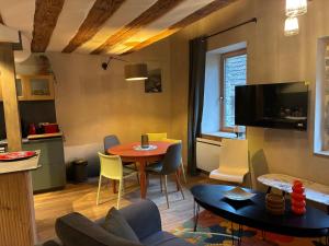 a living room with a table and chairs at Loft Cocooning et Lumineux in Arbois