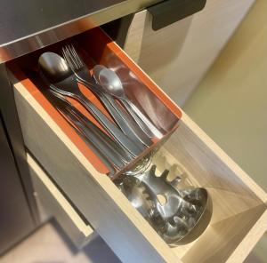 a drawer with silver utensils in a cabinet at Dublin City Centre Holiday Let in Dublin