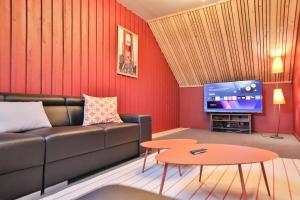 a living room with a couch and a tv at Le gîte l'écureuil in Malmedy