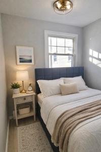 a bed with a blue headboard in a bedroom at Jefferson - 20 mins to Manhattan, NYC in West New York