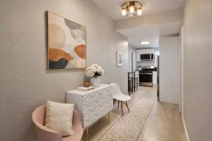 a living room with a table and chairs and a painting at Jefferson - 20 mins to Manhattan, NYC in West New York