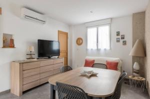 a living room with a table and a tv at Gîte Le Clos Controis in Le Controis En Sologne +14 photos