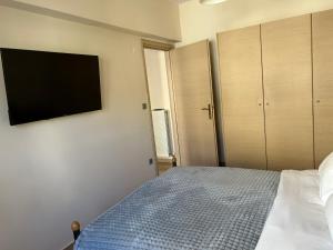 a bedroom with a bed and a flat screen tv at The Clock House No1 in Grevena