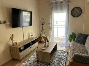 a living room with a couch and a tv at The Clock House No1 in Grevena