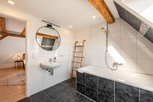 a bathroom with a bath tub and a sink at Sali Homes- Penthouse in Obersulm +75 photos