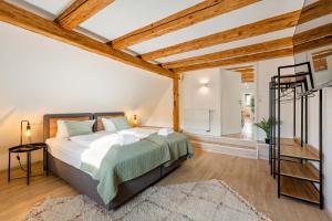 a bedroom with a large bed in a room with wooden ceilings at Sali Homes- Penthouse in Obersulm