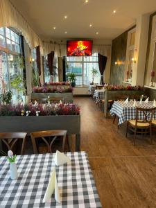 a restaurant with tables and flowers in a room at Kulinarische Zauberei in Rathenow