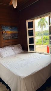 a bedroom with a large white bed with a window at Woods Hostel in Belo Horizonte +134 photos