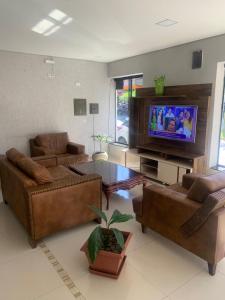 a living room with couches and a flat screen tv at Hotel Lider in Paranaguá