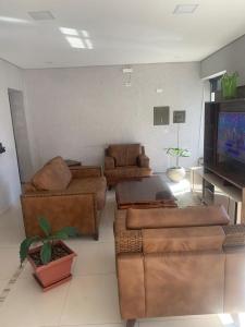 a living room with leather furniture and a flat screen tv at Hotel Lider in Paranaguá +6 photos