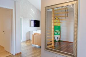 a mirror in a room with a surfboard on the wall at OleaVista in Portorož