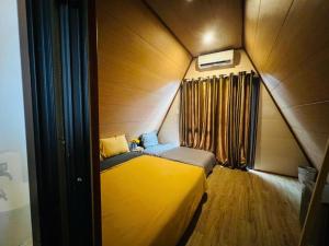 a small room with a yellow bed and a window at Mia's Homestay in Quang Ninh +14 photos
