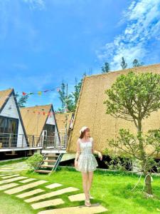 a woman in a dress walking on the grass at Mia's Homestay in Quang Ninh