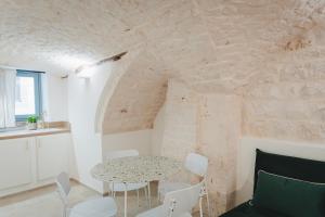 a dining room with a table and white chairs at Dimore Bianche, Santa Chiara in Putignano +33 photos