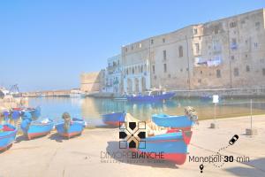 a group of boats in the water next to a building at Dimore Bianche, Santa Chiara in Putignano