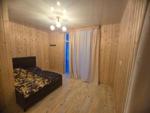 ein leeres Schlafzimmer mit einem Bett und einem Fenster in der Unterkunft goderdzi apartaments in Danisparauli
