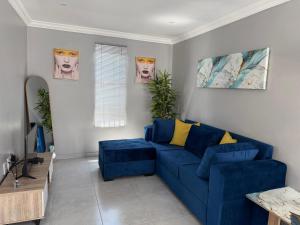 a living room with a blue couch and a table at Saviour Apartments in Mthatha