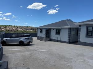 a car parked in a parking lot in front of a house at Saviour Apartments in Mthatha