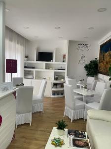 a white living room with white chairs and a table at Hotel Kennedy in Naples