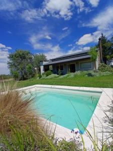 a swimming pool in front of a house at La Pasiva in Villa Giardino