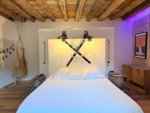 a bedroom with a large white bed with guns on the wall at La grange du dévoluy in Le Dévoluy