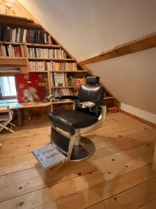 a barber chair sitting in a room with bookshelves at La grange du dévoluy in Le Dévoluy