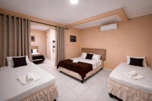 a hotel room with two beds and a window at Hotel Mitologia Algodoal in Algodoal