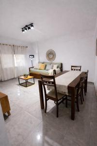 a dining room with a table and chairs and a couch at Departamento Palomar in Posadas
