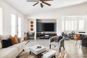a living room with a couch and a flat screen tv at Sandcastle House Pool, Spa, Golf! in Queen Creek