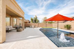 a patio with an umbrella and a swimming pool at Sandcastle House Pool, Spa, Golf! in Queen Creek