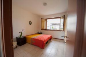 a bedroom with a bed with a red blanket and a window at villetta a schiera in Intra
