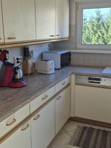 a kitchen with white cabinets and a microwave at maison prairie in Haguenau +4 photos