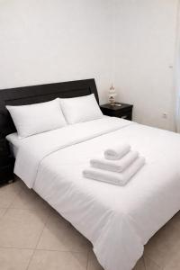 a white bed with three towels on top of it at Private Villa Sea View BBQ in Epanomi