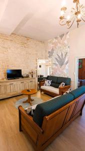 a living room with a couch and a tv at Le Pavillon des Dames in Migé