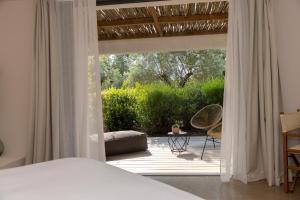a bedroom with a bed and a patio with a view at VILLA FLAKA Boutique Hôtel Wellness in Cargèse +82 photos