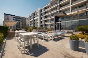 an outdoor patio with tables and chairs in front of a building at Nido x Gran Ciudad Nuevo Sur in Monterrey