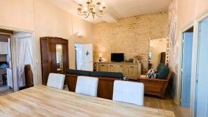 a dining room with a table and white chairs at Le Pavillon des Dames in Migé