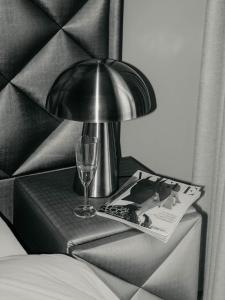 a table with a lamp and a magazine and a glass at Sunset Penthouse Antwerp in Antwerp