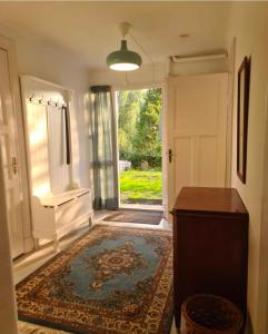 a hallway with a door and a rug and a room with a window at Nice and cosy flat in Molkom