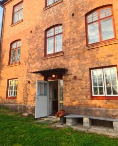 a brick building with a white door and windows at Nice and cosy flat in Molkom +6 photos