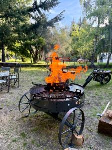 a grill with orange fires on top of it at Nevada Hostel in San Carlos de Bariloche