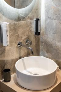 a white sink in a bathroom with a mirror at Oniro Suites Level 4 in Alexandroupoli +22 photos