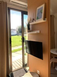 a television on a wall next to a sliding glass door at Casinhas da Póvoa- Turismo Natureza in Castelo de Vide