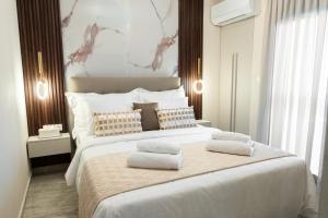 a bedroom with a large bed with two pillows on it at Oniro Suites Level 4 in Alexandroupoli