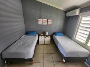 two beds in a room with two windows at Costa Azul Apartment in Punta Santiago