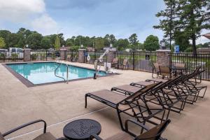 a swimming pool with chairs and a fence at Hampton Inn Benson in Benson